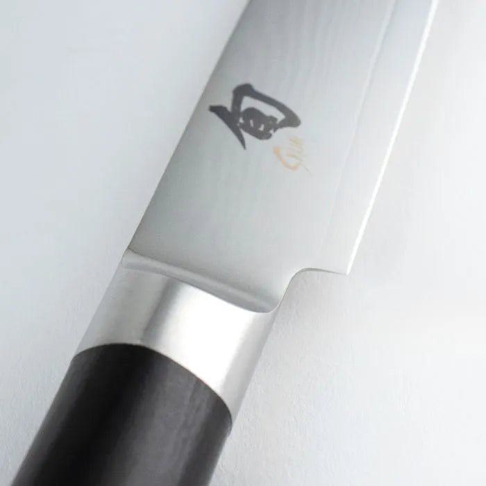 Close-up of a Shun Classic paring  knife with a black handle on a white background